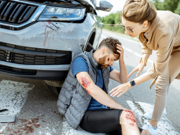 Woman driver with injured man on the road