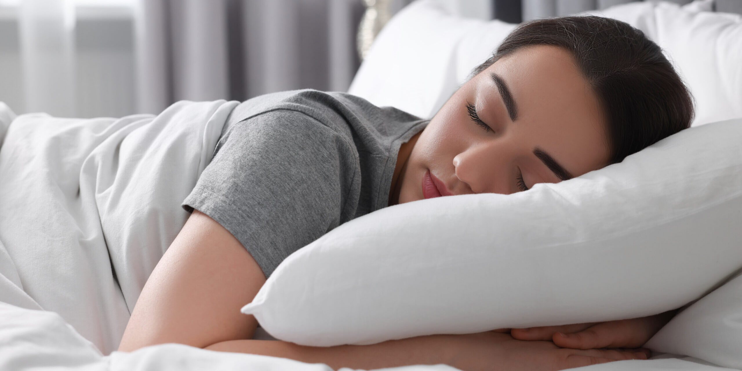 Beautiful young woman sleeping in soft bed at home