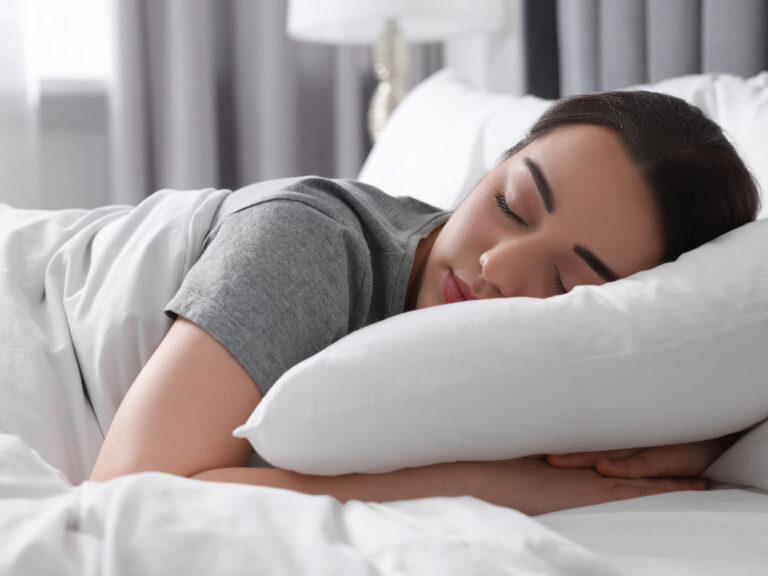 Beautiful young woman sleeping in soft bed at home